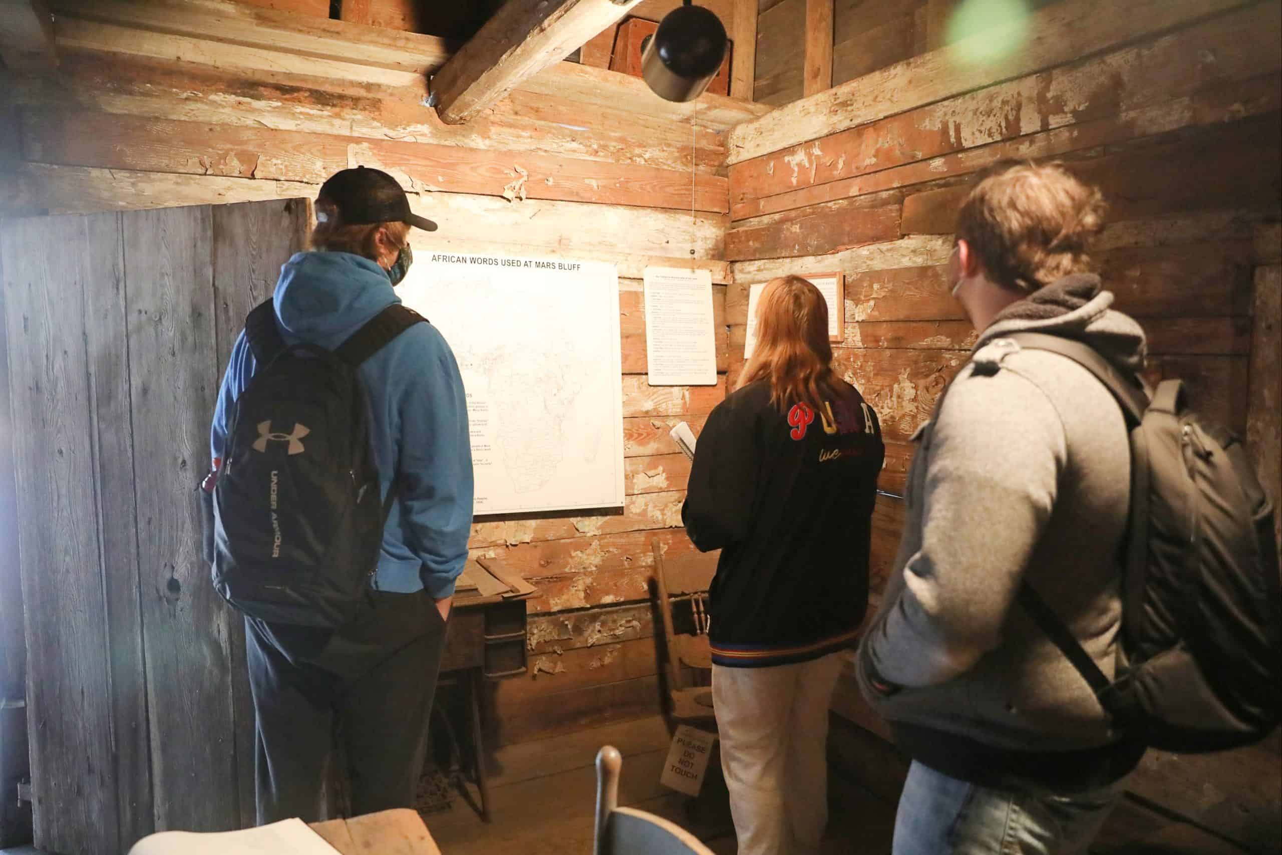 Students investigate the Hewn TImber Cabins.