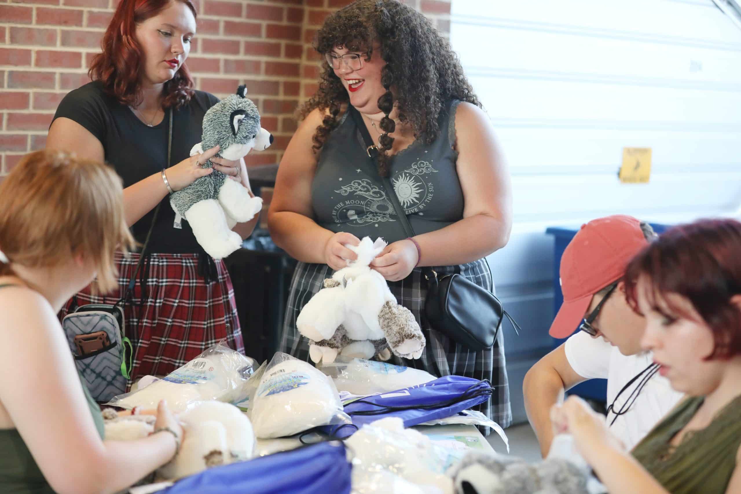 people smiling holding stuffed animals
