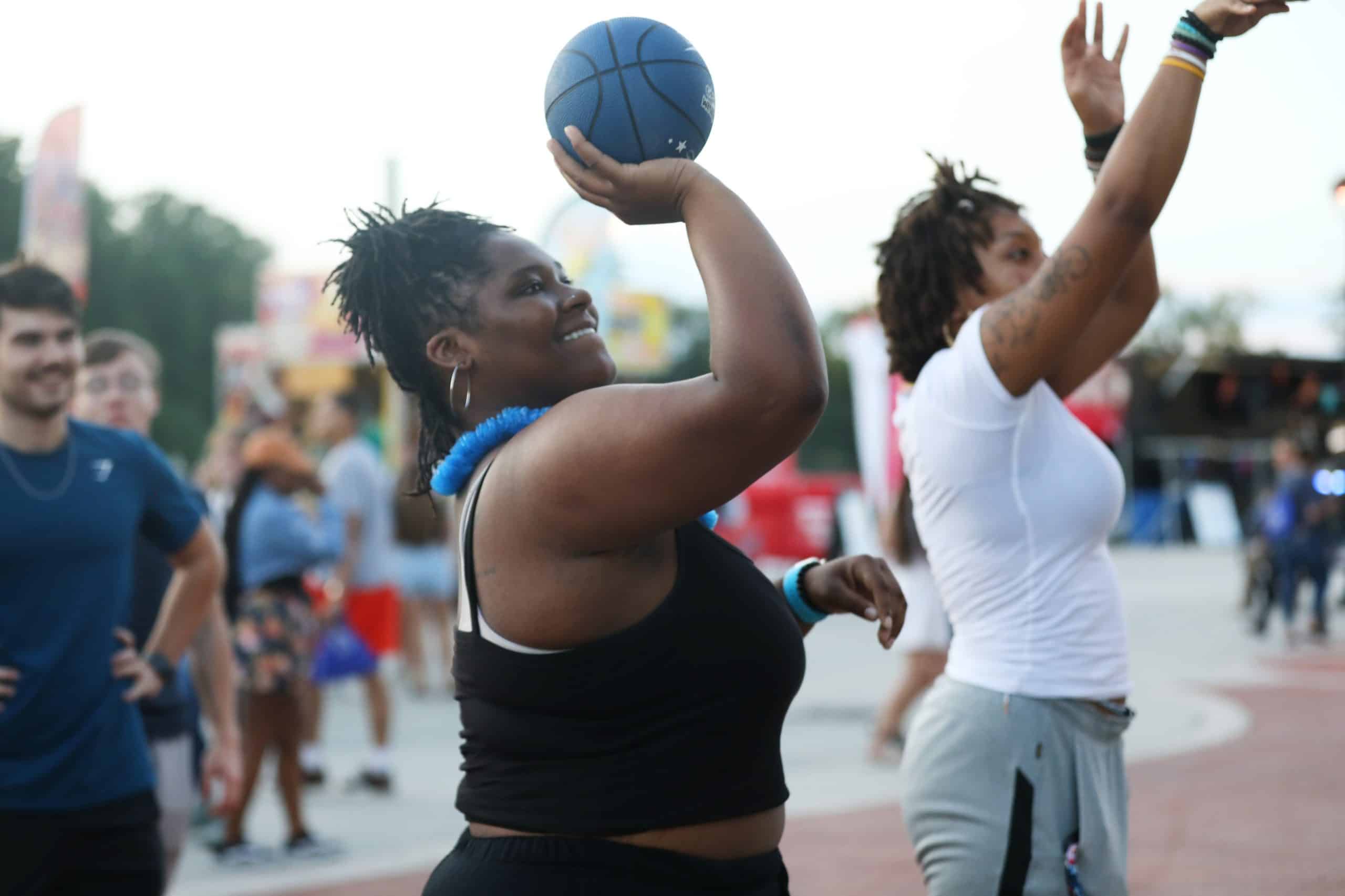 woman throwing basketball smiling