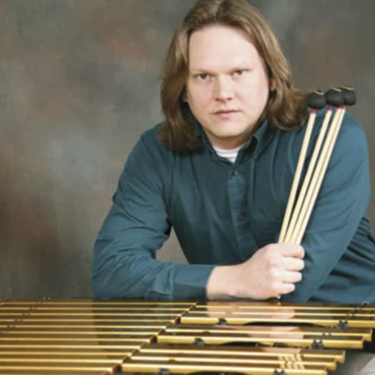 Photo of professor Reeves holding musical instrument