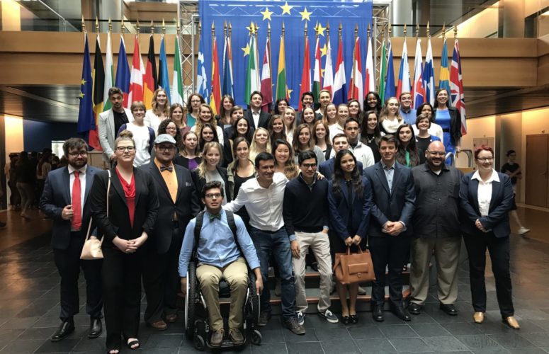 Group photo of students standing in front of flags