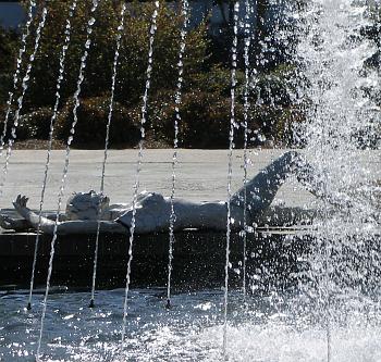 Artwork statue lying beside a fountain