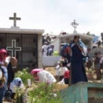 People crowded around tombs with crosses