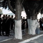 People wrapping white things around a tree