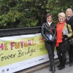 People posed in front of "Tower Bridge" sign