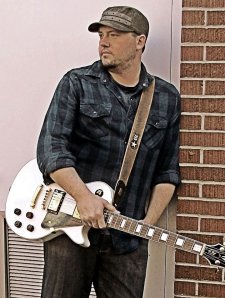 Joshua L. Adams holding a guitar