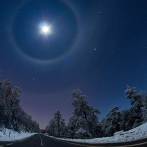 bright star in snowy night sky surrounded by lunar arcs