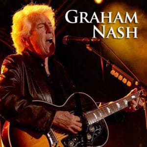Graham Nash singing on stage with guitar