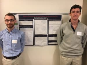 Two students standing with their research board