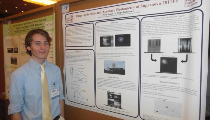 Rouse standing in front of his research poster