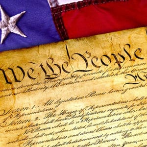 constitution on old paper laying upon a flag