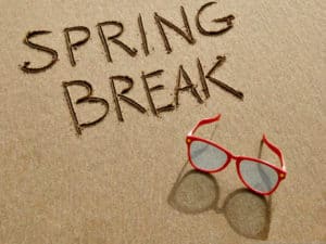 "Spring Break" is written in the sand.