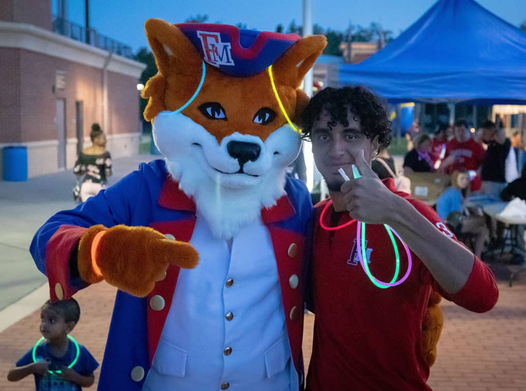 FMU-8242019-FirstFriday-3 A student poses with FMU mascot Frank the Fox.