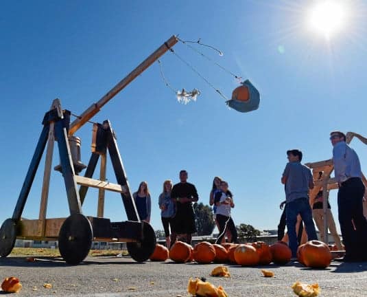 Students launch pumpkins with a trebuchet.