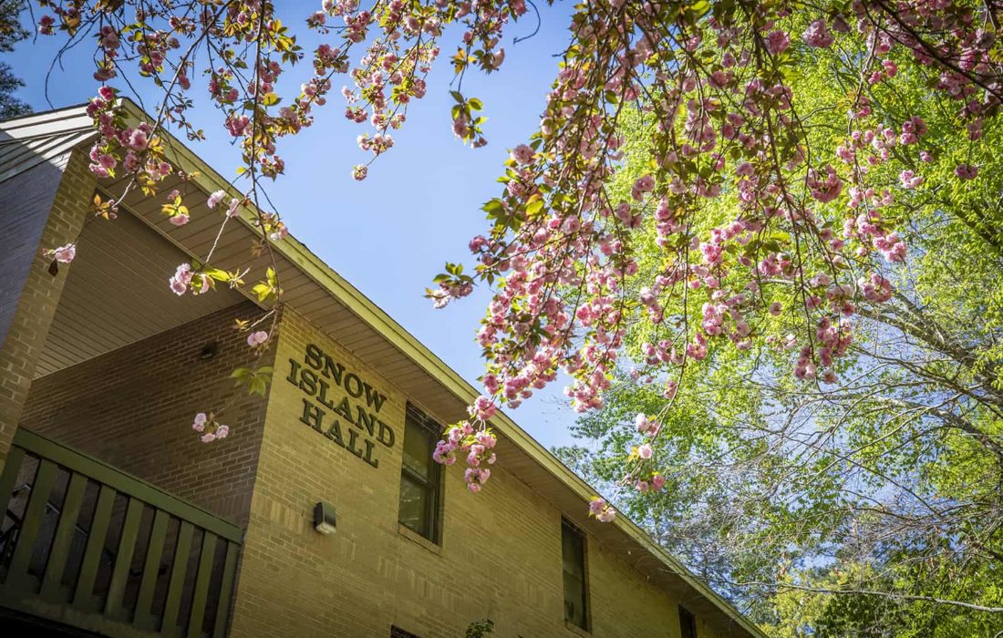 Trees bloom in front of Snow Island Hall.