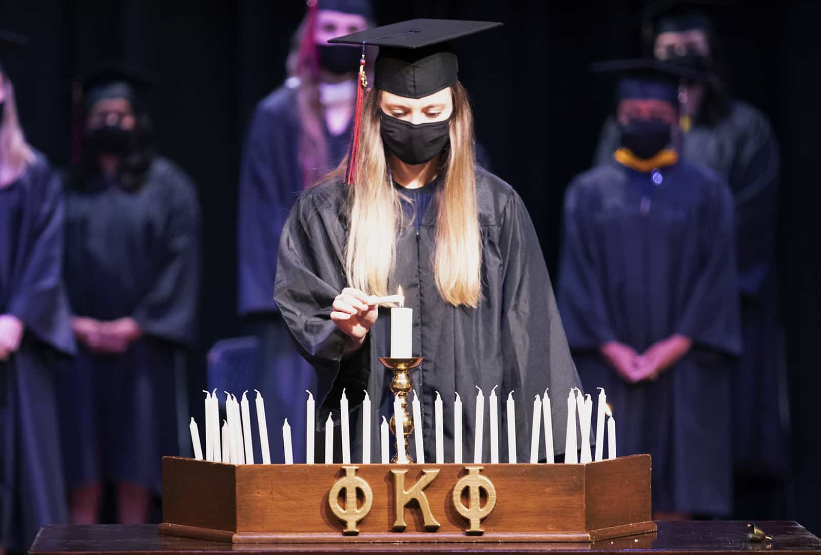 A new member of Phi Kappa Phi lights a candle.