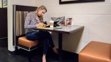 A students sits at a booth in Cauthen Cafe on FMU's main campus.