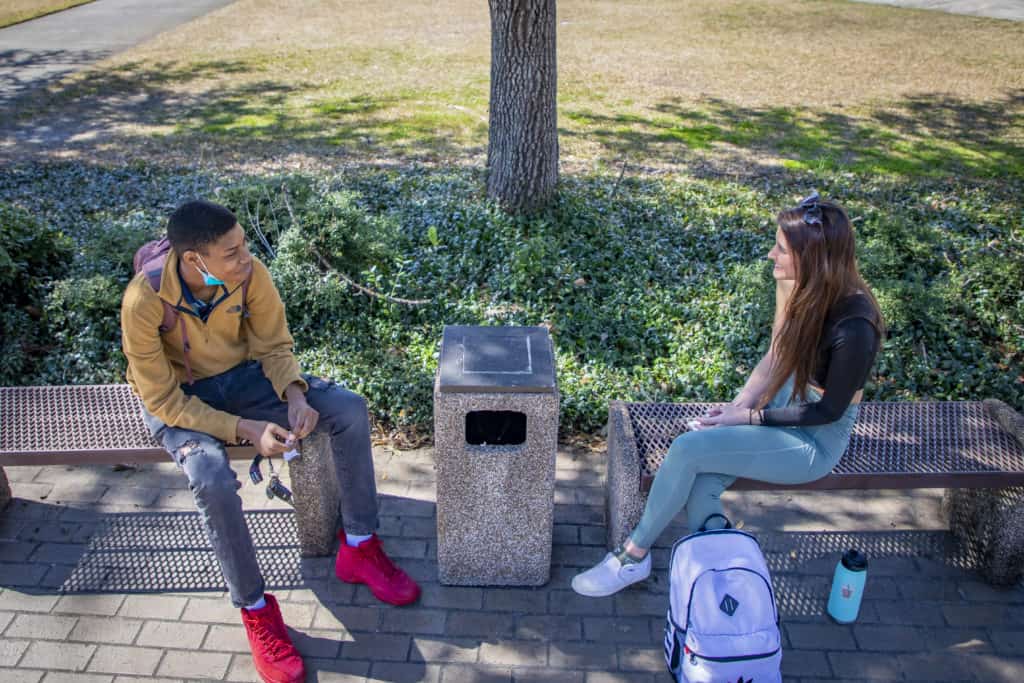 Students talk next to the fountain.