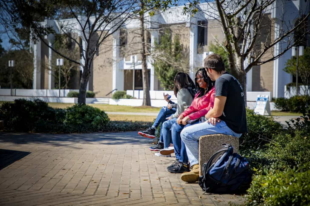 Students talk next to the fountain.