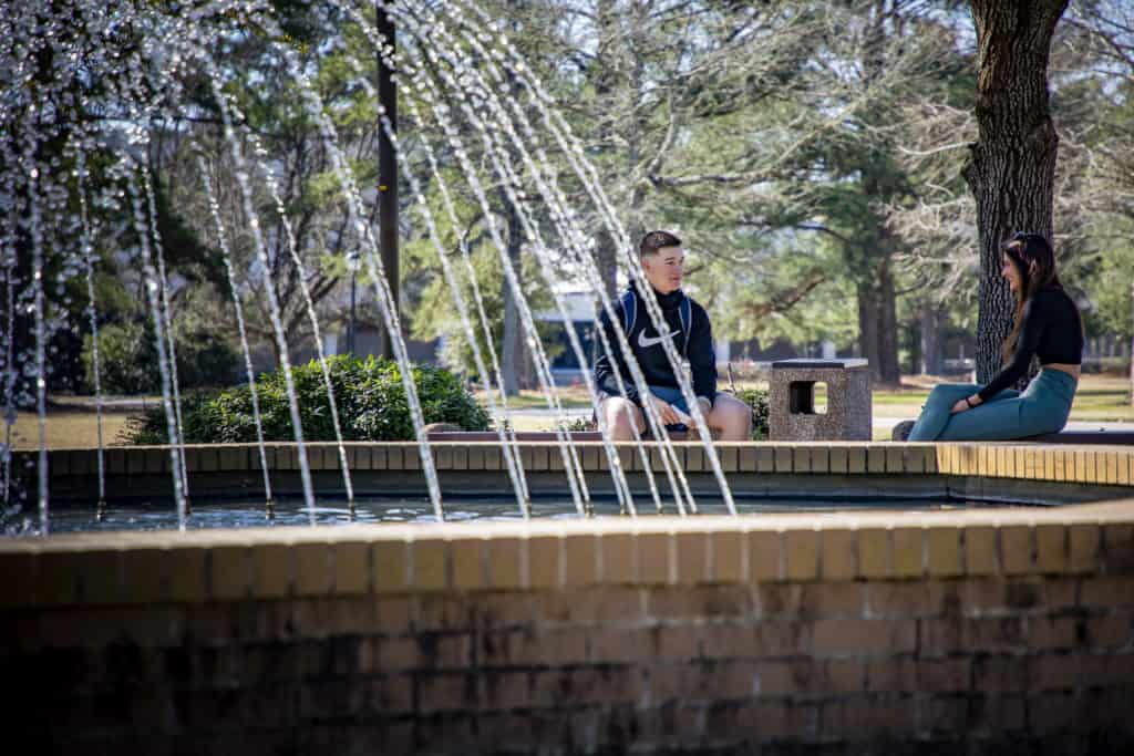 Students talk by the fountain.