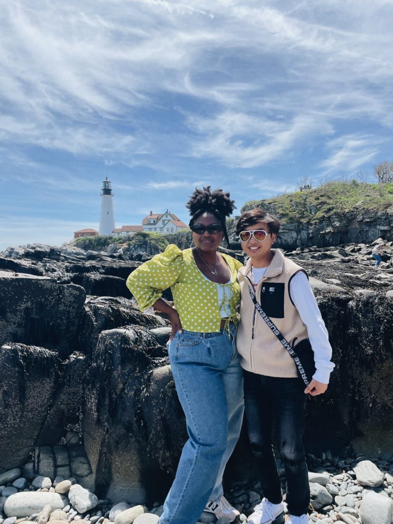 2 people posing in front of lighthouse