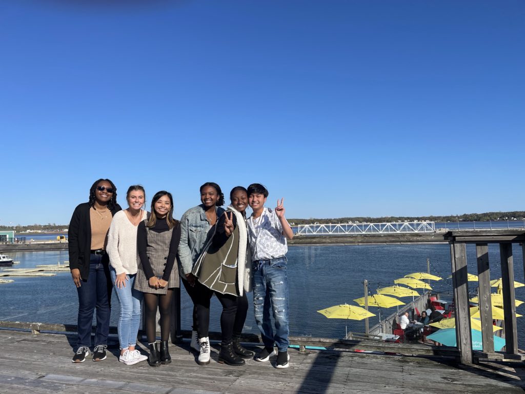 6 people posing in front of bridge