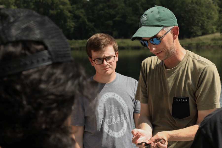 man holding fish for students